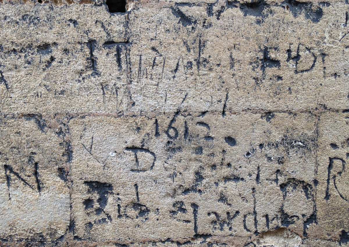 Seventeenth-century graffiti incised into a stone wall